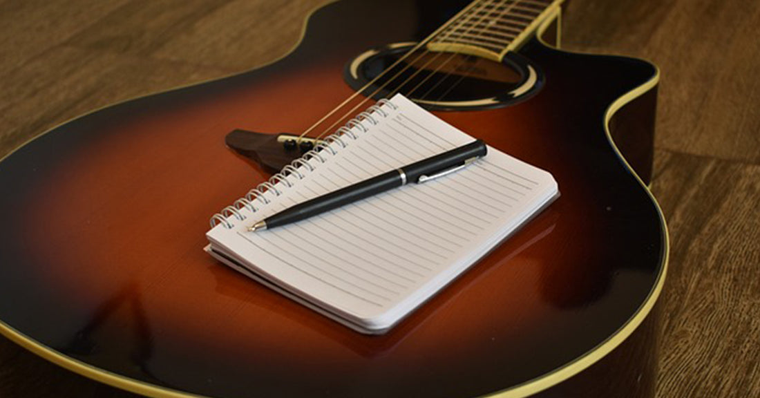 Gitaar en opschrijfboek van songwriter