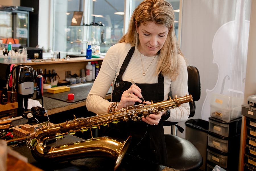 Technicus werkt aan een saxofoon in de blaaswerkplaats